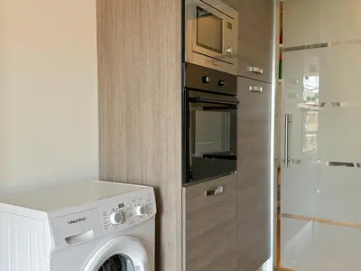 a washer and dryer in a small kitchen at Lumen House - Attico con Suite in Rome
