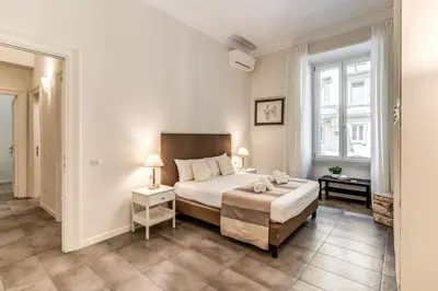 a bedroom with a large bed and two windows at Nest House Prati in Rome
