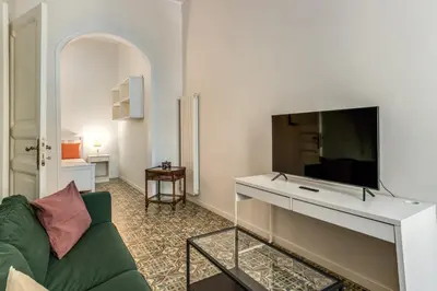 a living room with a green couch and a flat screen tv at Nest House Prati in Rome