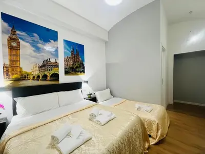 a bedroom with two beds and big ben at Rome Holiday Guesthouse in Rome