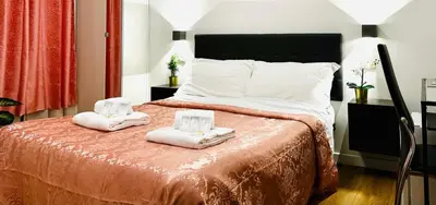 a bedroom with a bed with towels on it at Rome Holiday Guesthouse in Rome