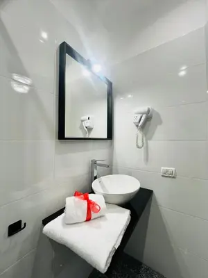 a white bathroom with a sink and a mirror at Rome Holiday Guesthouse in Rome