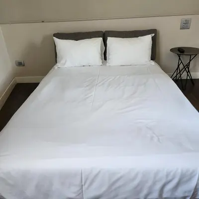 a large bed with white sheets and pillows at Rooms house corso 22 in Rome
