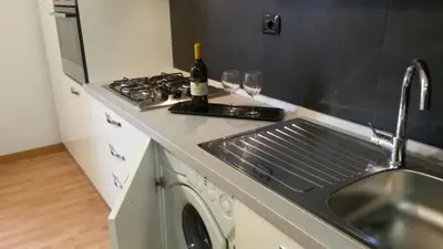 a kitchen with a sink and a stove with wine glasses at LCH-Lateran Charming House in Rome