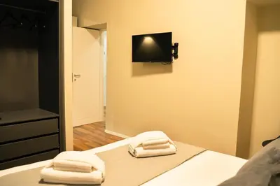 two towels on a bed with a television on the wall at Casa Del Grande in Trastevere in Rome