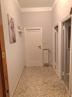 a hallway with a white door and a tile floor at Bilocale in Via degli Orti Variani in Rome