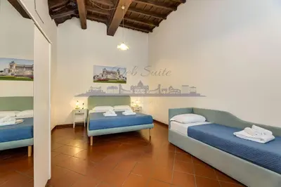 a room with two beds and a table in it at DEB Suite Campo de' fiori nel cuore di Roma in Rome