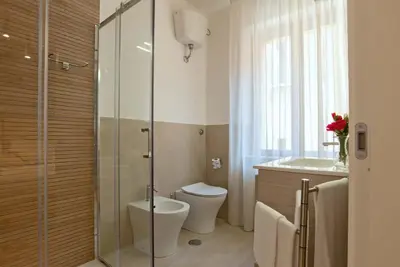 a bathroom with a shower and a toilet and a sink at Essence Guesthouse in Rome