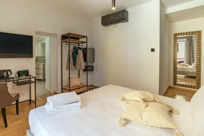 a bedroom with a large white bed and a mirror at Essence Guesthouse in Rome