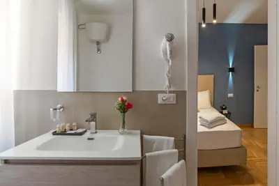 a bathroom with a sink and a bed in a room at Essence Guesthouse in Rome