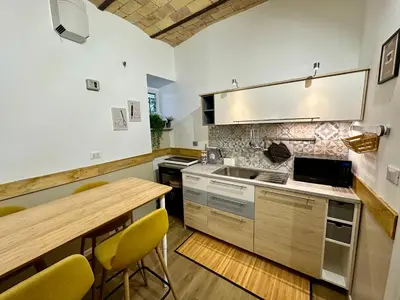 a kitchen with a wooden table and yellow chairs at Casa Happya - Metro A - Central Rome in Rome