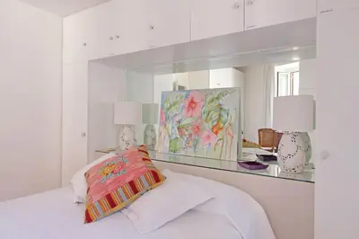 a white bedroom with a mirror and a bed at Magical Navona Duplex With Terrace by Halldis in Rome