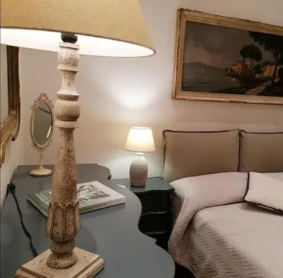 a bedroom with a table with a lamp and a bed at Borgo Pio 51 Apartment Vatican in Rome