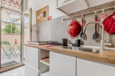 a kitchen with white cabinets and a sink at Sales in Trastevere in Rome