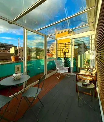 a balcony with a table and chairs on a building at Stanza in appartamento adiacente metro C in Rome