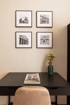 a black table with a chair and pictures on the wall at Candia Boutique Apartment in Rome