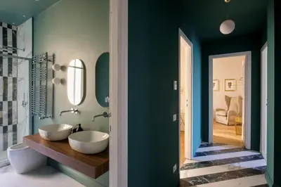 a bathroom with two white sinks and a green wall at Daplace - Lucilla Apartment in Rome