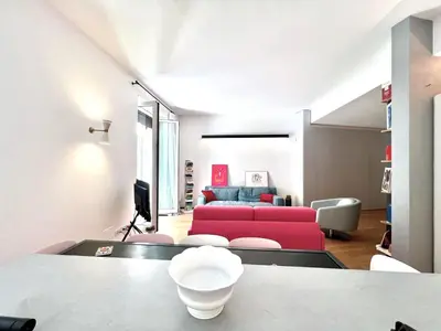 a living room with a red couch and a table at The Garden in Parioli in Rome