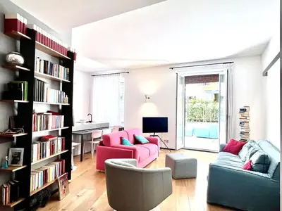 a living room with two couches and a book shelf at The Garden in Parioli in Rome