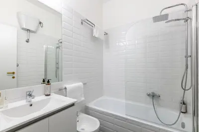 a white bathroom with a shower and a sink and a toilet at Fleming 67 by Hili in Rome