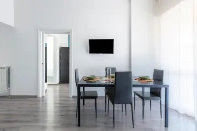 a dining room with a black table and chairs at Fleming 67 by Hili in Rome