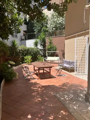 a patio with a wooden table and two chairs at Appartamento con giardino tra San Pietro e Stadio Olimpico Roma in Rome