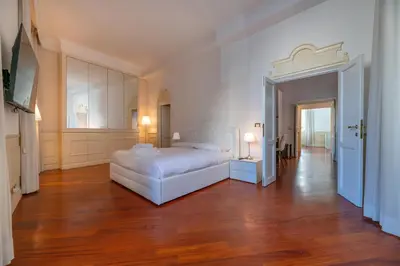 a bedroom with a white bed and a wooden floor at City Center Apartment - Pantheon in Rome
