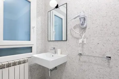a white bathroom with a sink and a mirror at Luciano Queen's Guest House in Rome