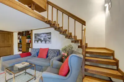a living room with a couch and a staircase at Dimora dell'Orso in Rome