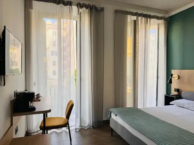 a bedroom with a bed and a desk and a window at My Maison Italy GuestHouse in Rome