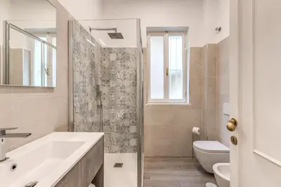 a white bathroom with a sink and a toilet at Frattina Grand Suite - Vacanze Romane Apartments in Rome