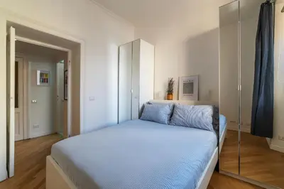 a bedroom with a bed with blue sheets and a mirror at Valenziani Escape - Pretty Homes in Rome