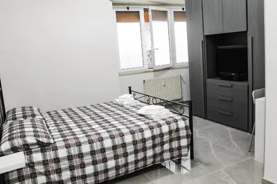 a bedroom with a bed with a plaid blanket at Silver Rose Guest House in Rome