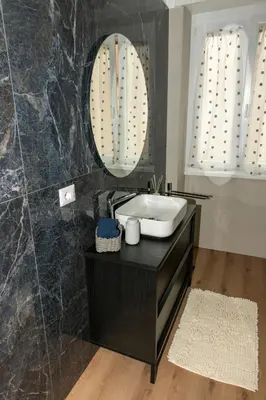 a bathroom with a sink and a mirror at Casa Caterina Holiday House - Bright Modern Apartment Near Trastevere in Rome