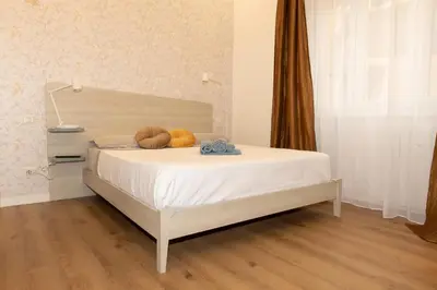 a bedroom with a white bed with two balls on it at Casa Caterina Holiday House - Bright Modern Apartment Near Trastevere in Rome