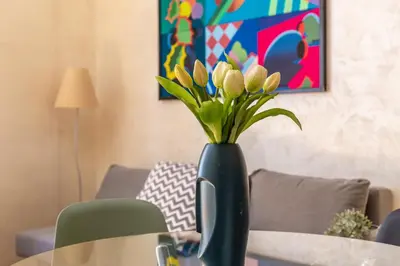 a black vase with yellow flowers in it on a table at iFlat Bright & Comfortable Navona apartment in Rome