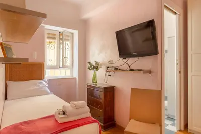 a bedroom with a bed and a tv on the wall at iFlat Bright & Comfortable Navona apartment in Rome