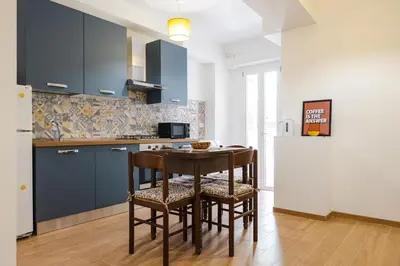 a kitchen with blue cabinets and a table and chairs at Domus Angelina in Rome