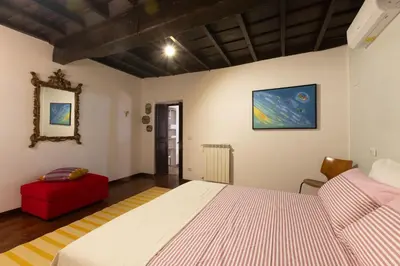 a bedroom with a bed and a red ottoman at Dolce Far Niente in Rome