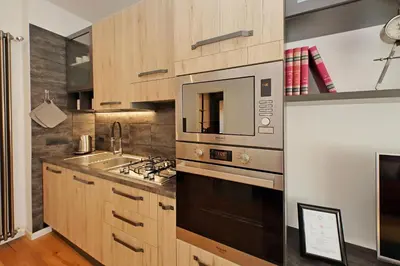 a kitchen with a stove and a microwave at Vestali House in Rome