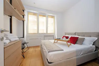 a white bedroom with a bed and a table at Vestali House in Rome