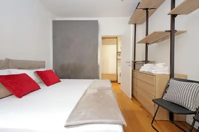 a bedroom with a large white bed with red pillows at Vestali House in Rome
