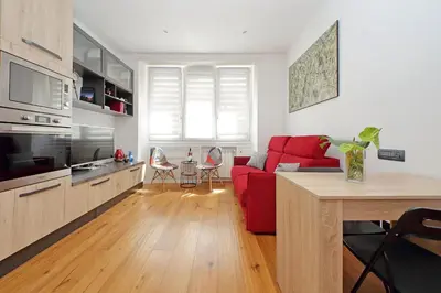 a living room with a red couch and a kitchen at Vestali House in Rome