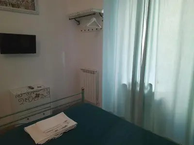 a bedroom with a bed and a tv and a curtain at Casa Roma Affittacamere in Rome