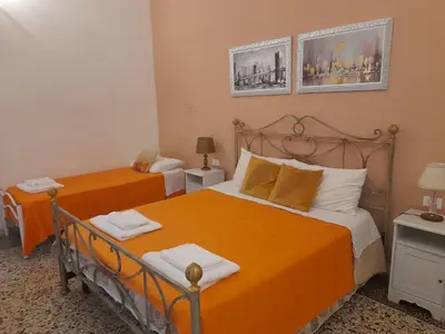 a bedroom with two beds with orange sheets at Casa Roma Affittacamere in Rome