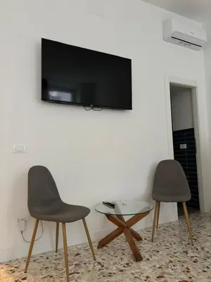two chairs and a table with a tv on a wall at Harmony in Rome ll in Rome