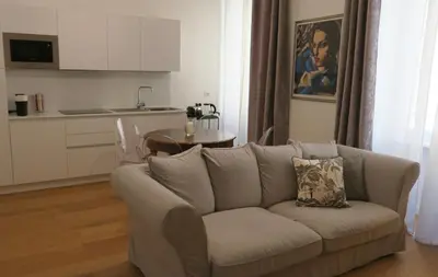 a living room with a couch and a kitchen at Scipioni245 Charme Apartment in Rome
