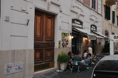a group of people sitting at tables outside a store at CARDINAL STUDIO - 2 steps from Vatican & Ottaviano metro in Rome