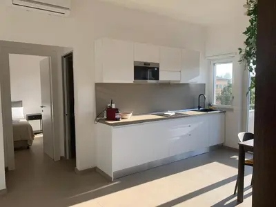 a kitchen with white cabinets and a counter top at Sunshine Suite in Rome