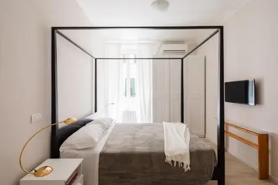 a bedroom with a large bed and a tv at Suite Lucrezio in Rome in Rome